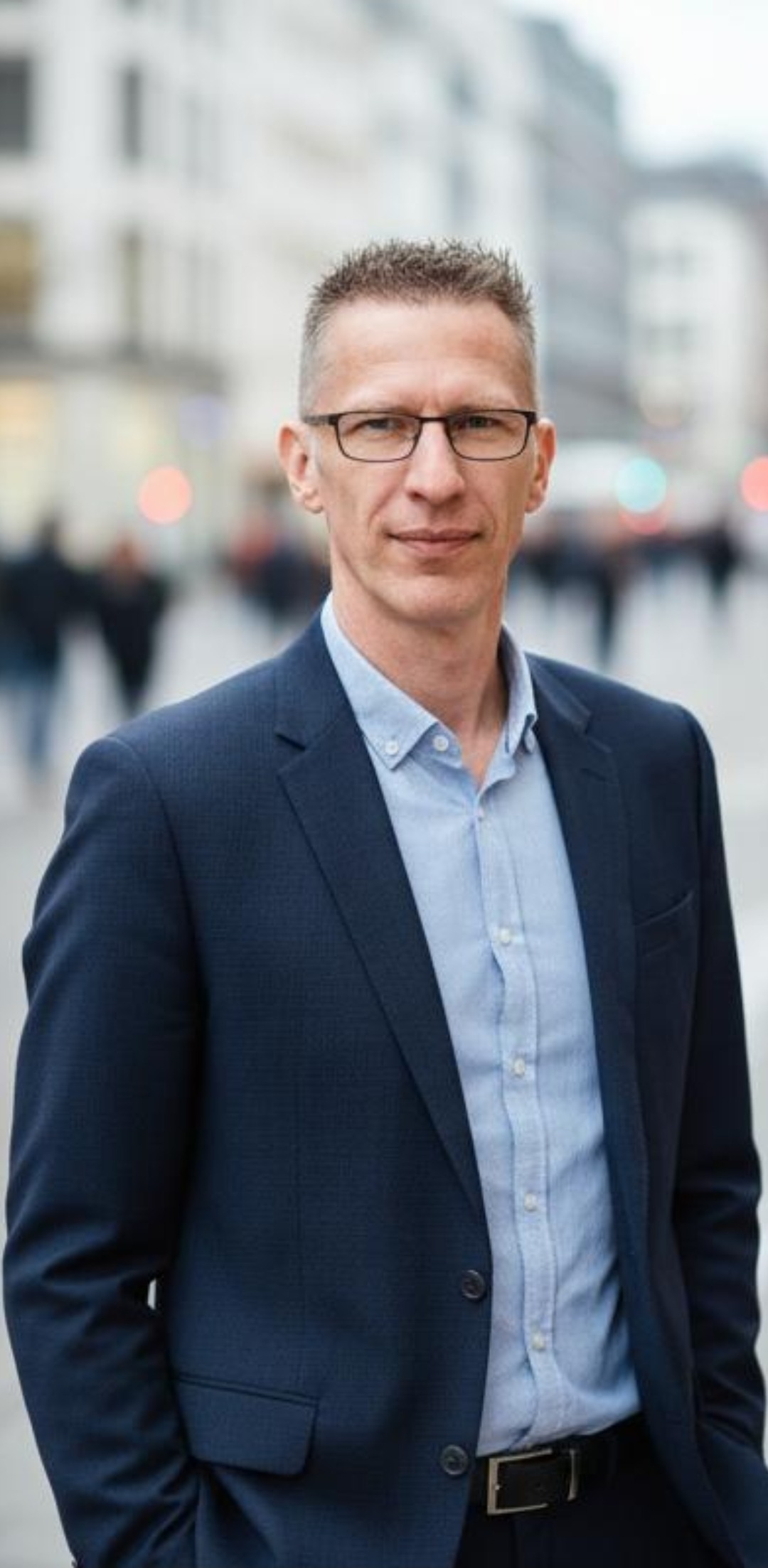 André Dieckmann, Inhaber Immobilien Ratgeber, Porträt in einer Stadtszene, dunkelblaues Sakko und hellblaues Hemd.